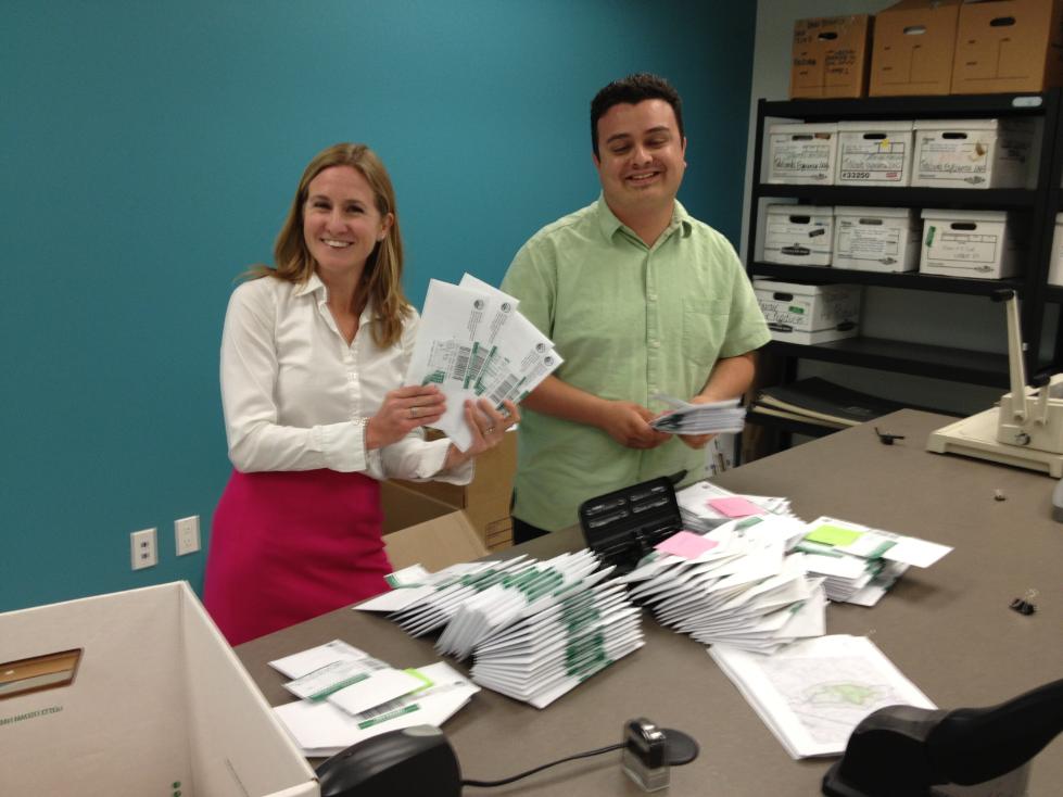 people sorting through public outreach mailings