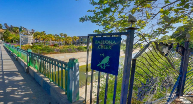 a Ballona Creek sign on a gate overseeing the creek