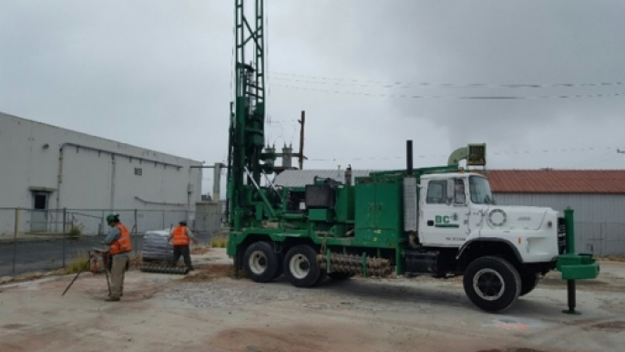 a green truck with a crane