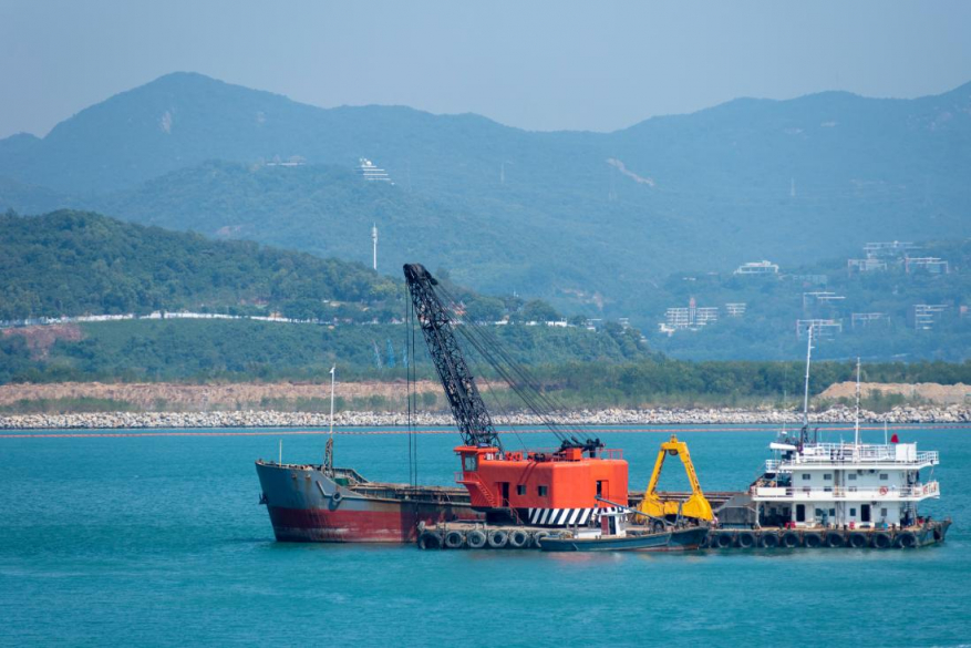 a crane on a boat dredging the water