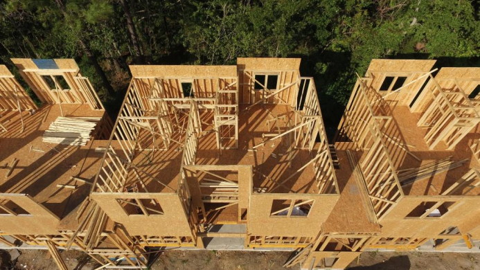 multi-family homes under construction with trees in the background