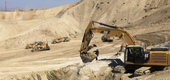 a construction site with a person and an excavator
