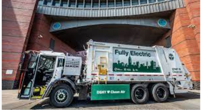 a fully electric dump truck parked in front of a building