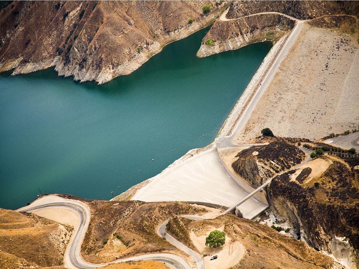 a road next to a body of water with a dam in it