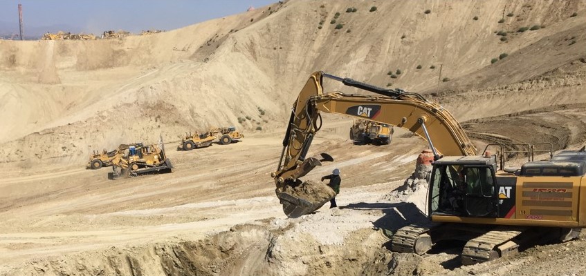 a construction site with a person and an excavator