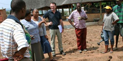 Group of people standing around talking in a village